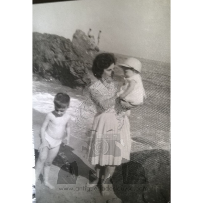 SEÑORA CON DOS NIÑOS EN LA COSTA