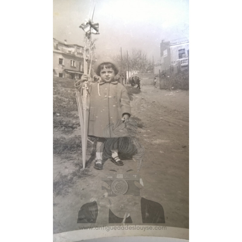 NIÑA CON UNA PALMA EN UN MEDIO RURAL
