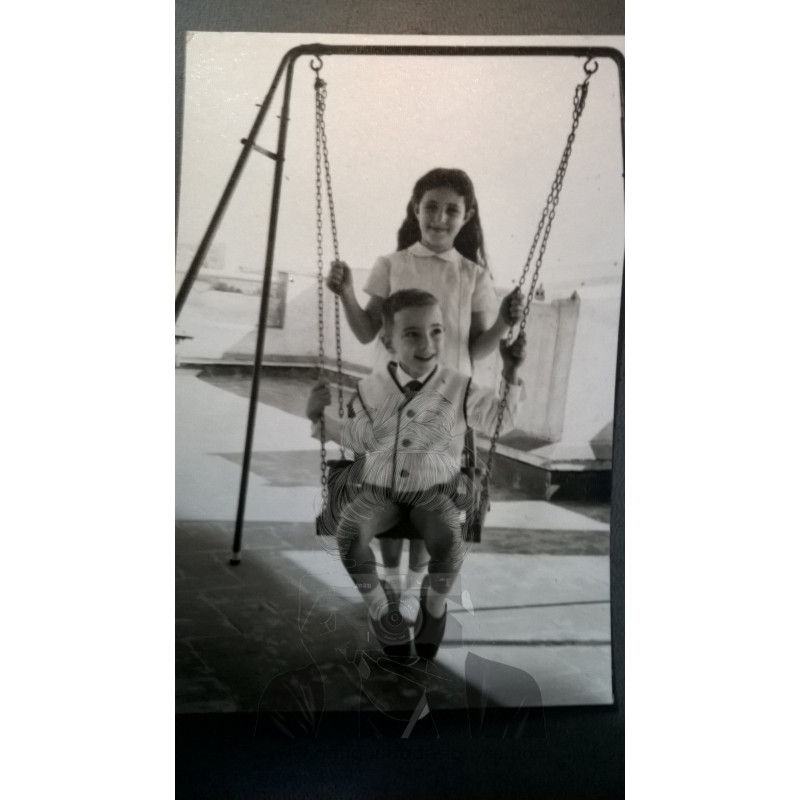 PAREJA MIXTA DE NIÑOS EN COLUMPIO